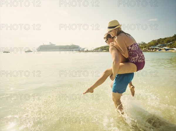 Caucasian couple playing in tropical ocean