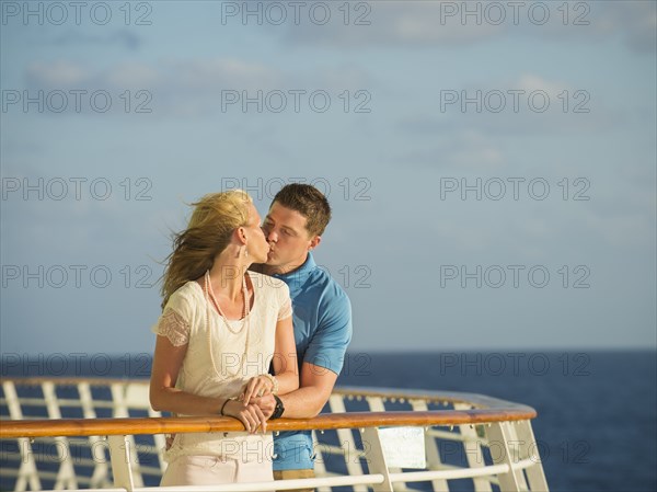 Caucasian couple kissing on boat deck