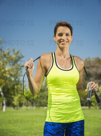 Mixed race woman holding jump rope in park