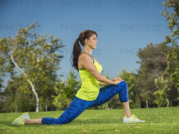 Mixed race woman stretching in park