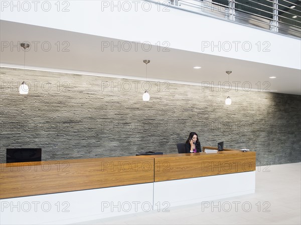 Caucasian receptionist working at office front desk