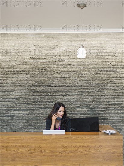 Caucasian receptionist working at office front desk