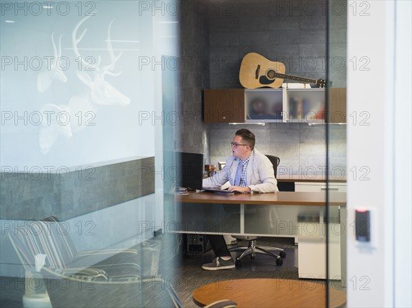 Caucasian businessman working at desk in office