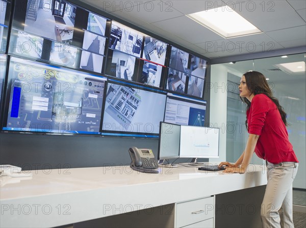 Caucasian security officer watching surveillance cameras