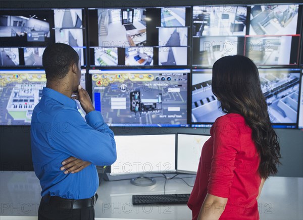 Security officers watching surveillance cameras