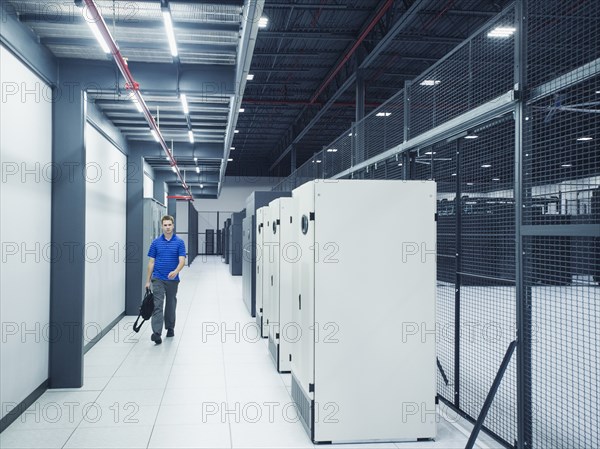 Caucasian businessman walking in server room