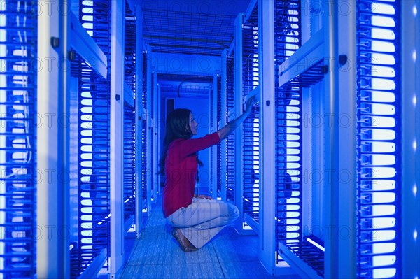 Caucasian businesswoman working in server room
