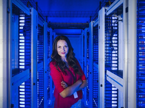 Caucasian businesswoman smiling in server room