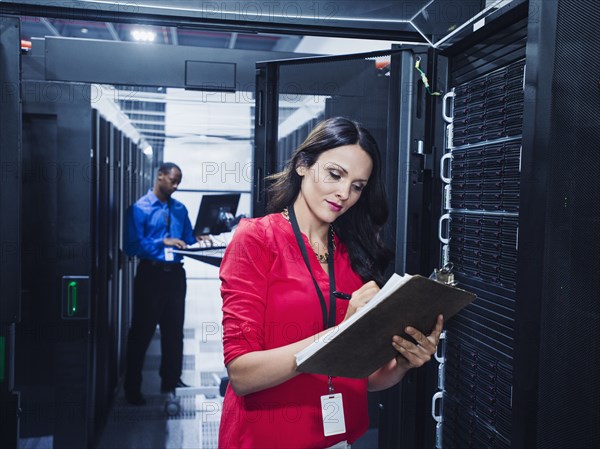 Business people working in server room