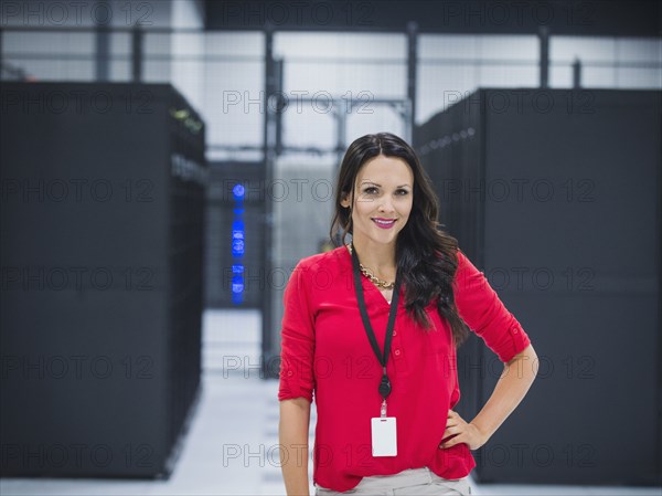 Caucasian businesswoman smiling in server room