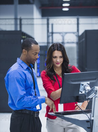 Business people using computer in server room