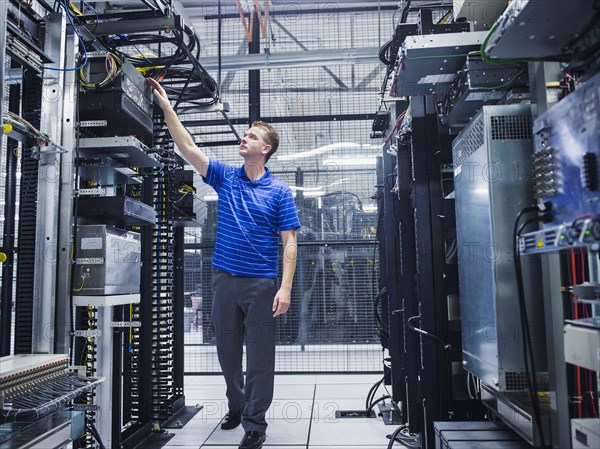 Caucasian technician working in server room