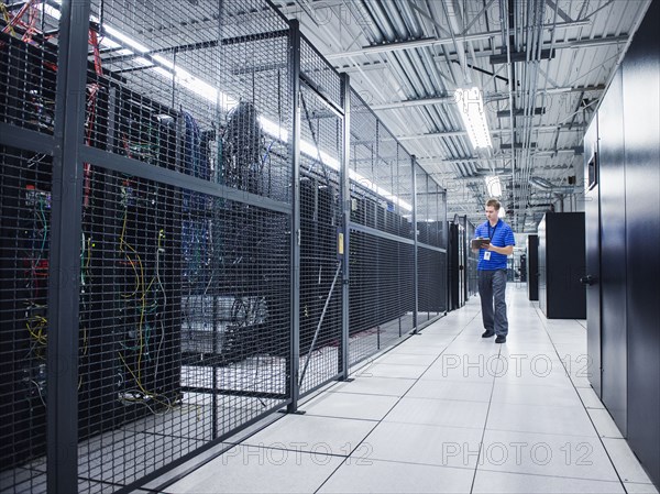 Caucasian technician using digital tablet in server room