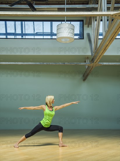 Caucasian woman practicing yoga in studio