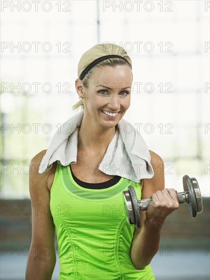 Caucasian woman lifting weights in gym