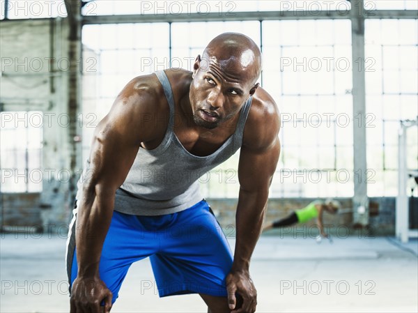 Close up of Black athlete resting in warehouse gym