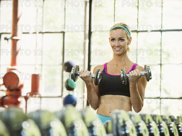Caucasian woman lifting weights in gym