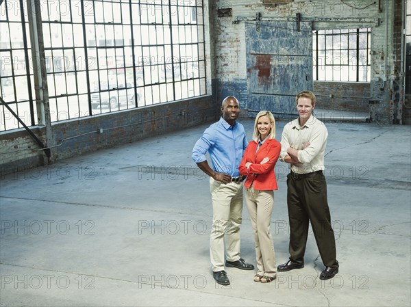 Business people smiling in empty warehouse