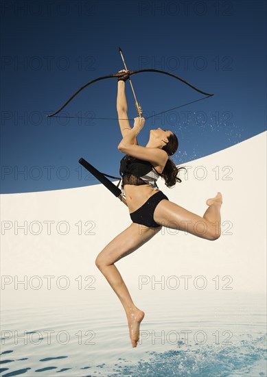 Caucasian woman aiming bow and arrow