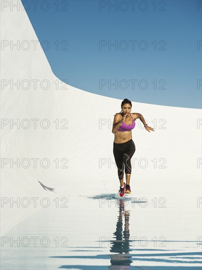 Mixed race woman running on water surface