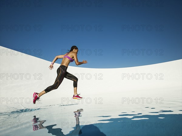 Mixed race woman running on water surface