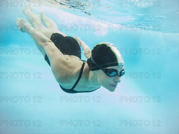 Caucasian swimmer diving into swimming pool