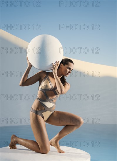 Caucasian woman holding sphere on ice floe