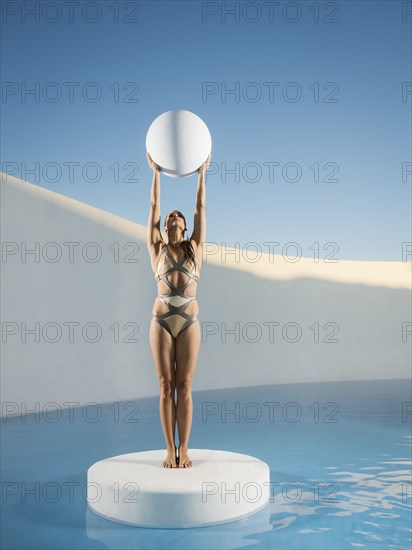 Caucasian woman holding sphere on ice floe