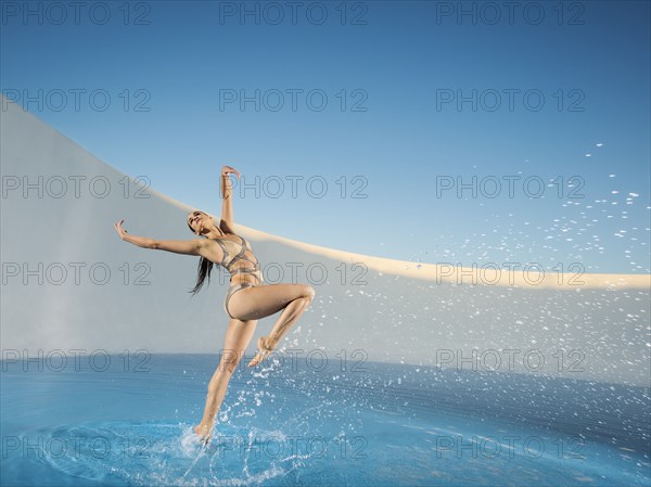 Caucasian woman dancing on swimming pool