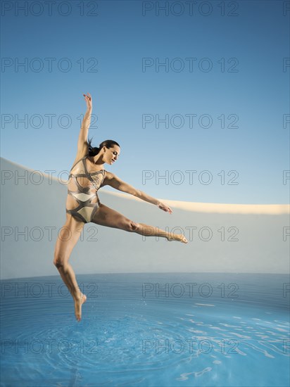 Caucasian woman dancing on swimming pool