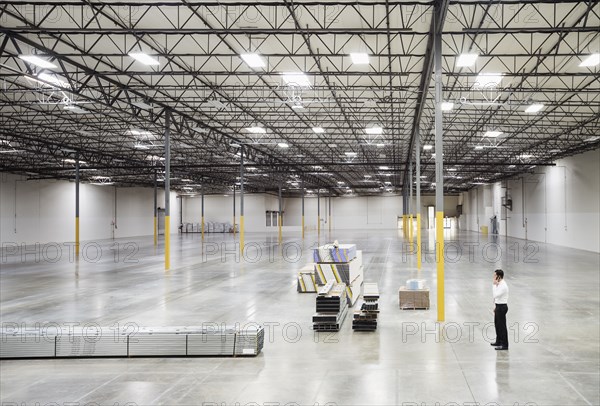 Caucasian businessman standing in empty warehouse