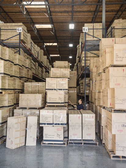 Caucasian worker examining cardboard boxes in warehouse