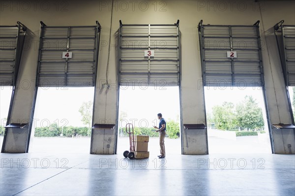 Caucasian worker examining cardboard boxes in warehouse