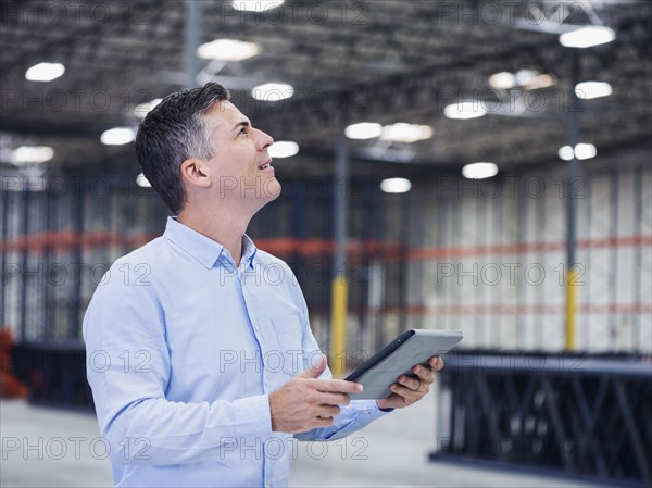 Caucasian businessman using digital tablet in empty warehouse