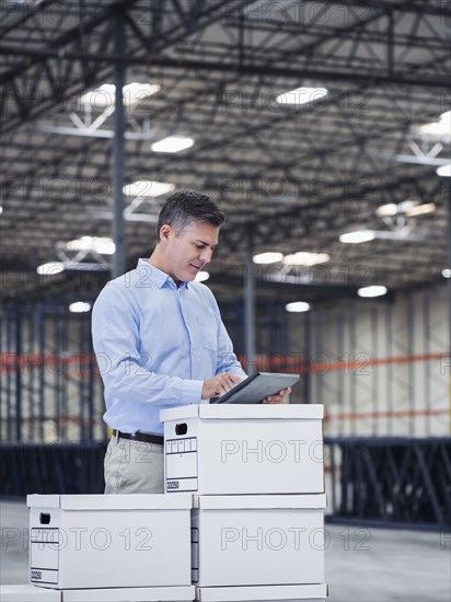 Caucasian businessman using digital tablet in empty warehouse
