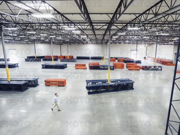 High angle view of Caucasian businessman walking in empty warehouse