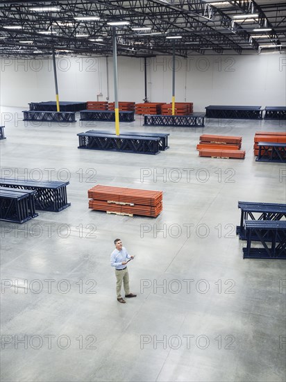 High angle view of Caucasian businessman standing in empty warehouse