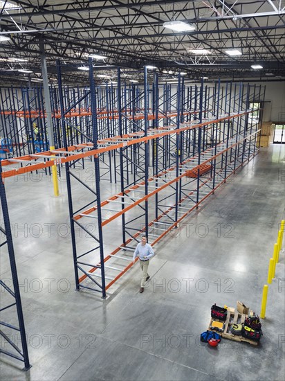 High angle view of Caucasian businessman walking in empty warehouse