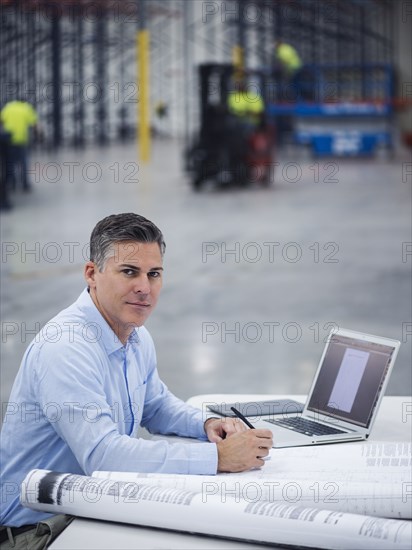 Caucasian architect working in warehouse