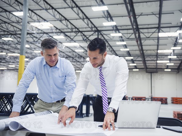 Caucasian architects working in warehouse