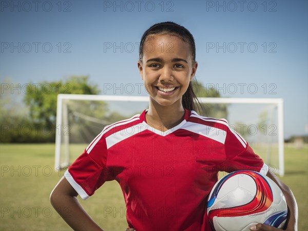 Mixed race soccer player standing on field