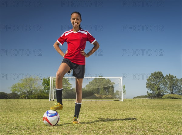 Mixed race soccer player standing on field