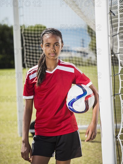 Mixed race soccer player standing in goal