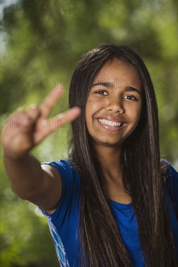 Mixed race girl giving peace sign