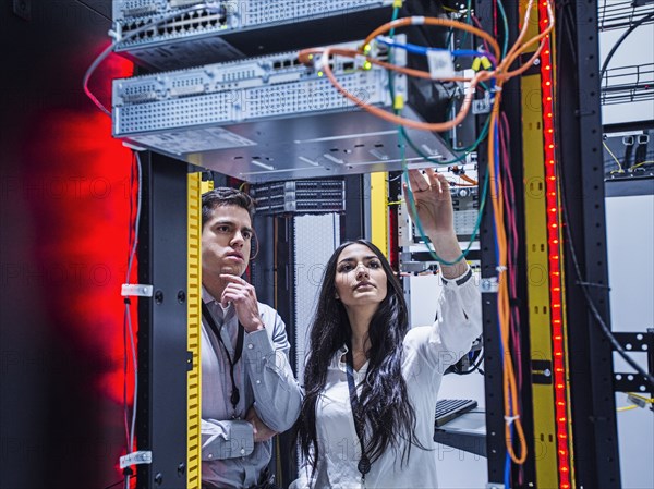 Technicians examining computer in server room