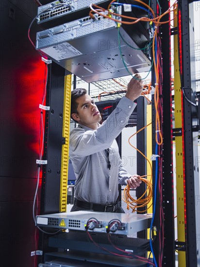 Hispanic technician working in server room