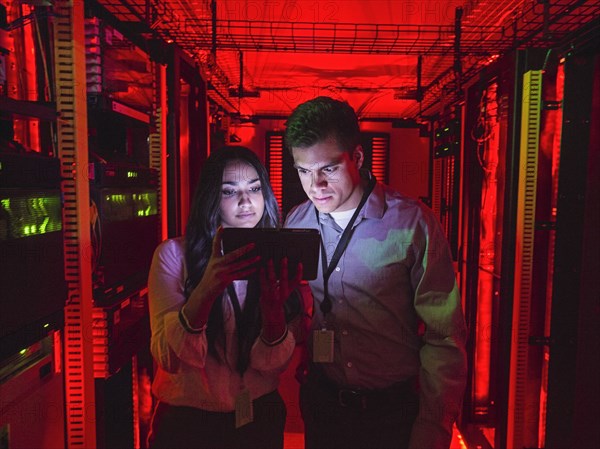 Technicians using digital tablet in server room