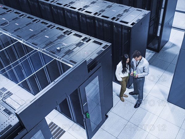 High angle view of technicians talking in server room
