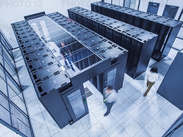 High angle view of technicians walking in server room