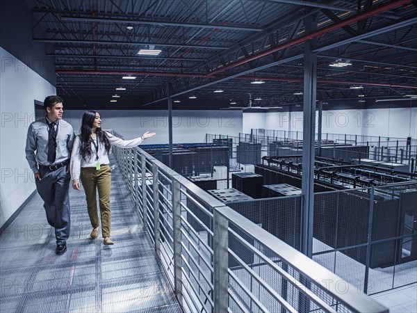 Businesswoman showing colleague server room from balcony